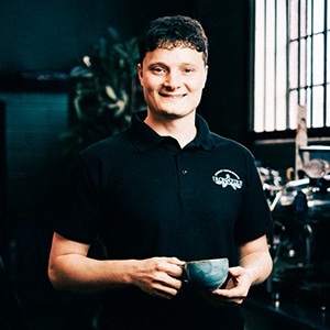 Joe front facing holding a coffee cup